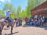 A wrangler demonstrates use of the reins on a horse.