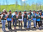 All suited up with vests and helmets ready to ride, this group waves to the camera.