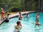 Parents and their babies spend time in the Red Creek Lodge's pool. Swim diapers required for all babies in the pool.