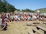 A large group of young women gathers around the stage for a fireside talk.