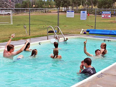 Youth swim in the semi-rectangular pool.