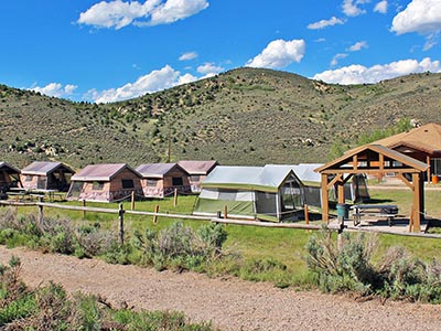 Tent Cities at Reid Ranch have green tents or tents that look like log cabins.