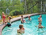 Parents and their babies spend time in the Red Creek Lodge's pool. Swim diapers required for all babies in the pool.