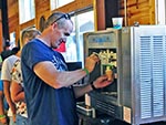 A man helps himself to some soft-serve ice cream for dessert.