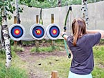 Most the arrows this girl shot are in the red circles just outside the bull's eye, and she is ready for one more try.