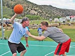 Two men playing basketball on the Sports Court.