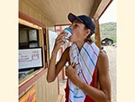 A teenager eats a shaved ice treat, available at the Snack House.