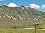 The US flag proudly waves in front of a mountain backdrop.